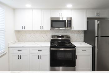 Kitchen with white cabinetry and black appliances